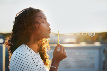 Attractive woman blowing soap bubbles