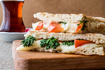 Turkish Bazlama Tost / Toast sandwich with melted cheese, tomatoes, dill and tea.