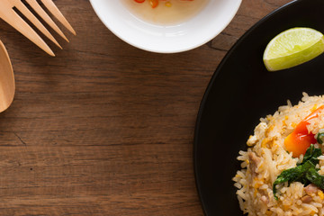Close up copyspace surrouding with wooden fork and spoon, plate of fried rice and chili fish sauce