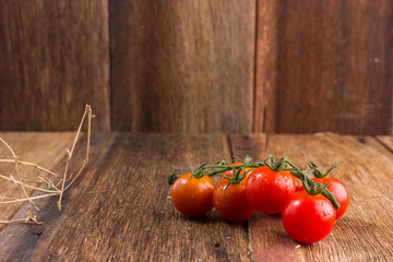 Fresh cherry tomatoes on old wooden background