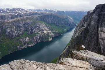 panoramic view of Norwegian fjord clamped by huge mountains in cloudy day