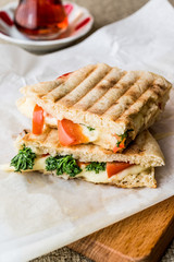 Turkish Bazlama Tost / Toast sandwich with melted cheese, tomatoes, dill and tea.