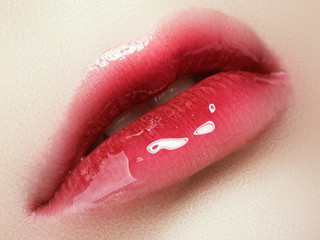 Close-up beautiful female lips with bright lipgloss makeup. Perfect clean skin, light fresh lip...