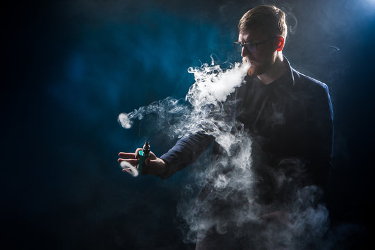 The man releases rings of smoke. Tricks with smoke.