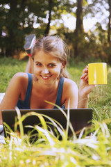 beautiful woman working working with a laptop in a green park outdoors  (freelance, time management, success, freedom)