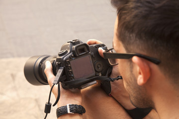 Young photographer viewing his photos on the back of the camera LCD display