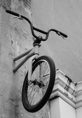 Fototapeta na wymiar Bike attached to the wall in Marais quarter of Paris (France). Black and white