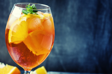 Alcohol cocktail with orange juice, fruit, bitter and ice, selective focus