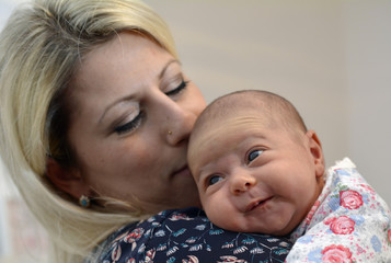 mutter hält ihr baby im arm