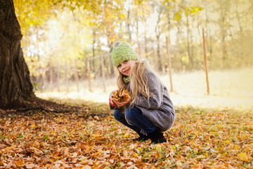 little girl walks in the autumn