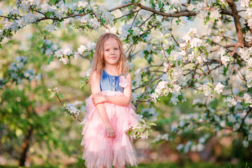 Cute girl in blooming apple tree garden enjoy the warm day