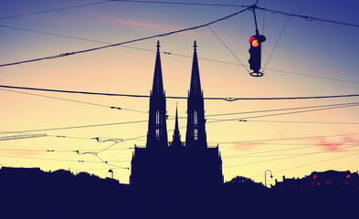 Silhouette of the Votive Church (Votivkirche) and suspended stoplight at dusk, color toning applied.