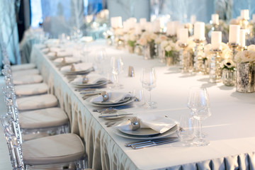 Banquet table decor. Candles in vases and flowers