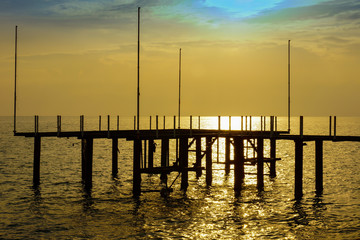 Man-made wooden pier for sunbathing against sunset