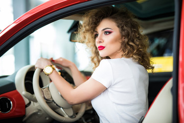 Fototapeta na wymiar Rear view of attractive young woman in casual wear looking over her shoulder while driving a car