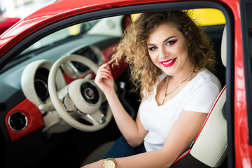 Fototapeta na wymiar Pretty young woman seat in her new car