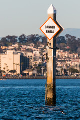 A shoal boating warning sign in a harbor.