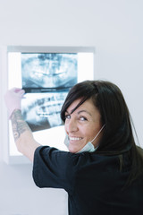 Female doctor dentist looking at x-ray