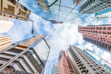 Fototapeten Panoramic wide angle view and perspective to steel light background of glass high rise buildings. Causeway Bay, the popular luxury shopping district in Hong Kong Island. © bennymarty