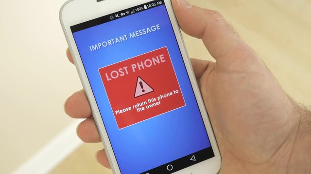 Hand holding a lost smartphone showing a message.