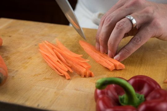 Close Up of Hands Cutting Long Strips of Carrots