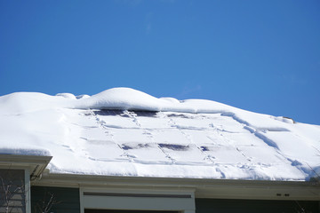 solar panel on the roof covered by snow after blizzard in winter