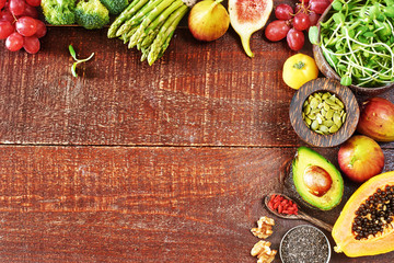 Fototapeta na wymiar Top view of fresh vegetables, fruits, superfoods, nuts and seeds. Wooden texture background with copy space.