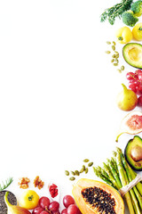 Clean eating or raw diet food vertical background with a copy space. Top view of fresh vegetables, fruits, seeds and nuts (papaya, asparagus, figs, broccoli, avocado, grape, tomato, goji, chia).