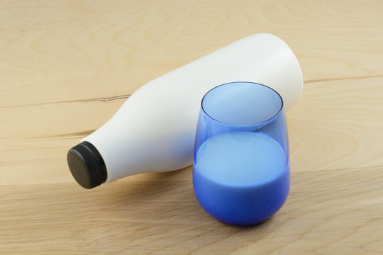 Bottle and glass of vanilla kefir on wooden table
