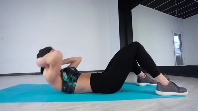 fitness. sport, training and lifestyle concept - woman doing exercises on mat in gym