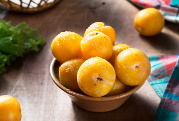 Yellow ripe plums on wooden table