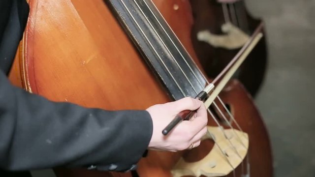 Contrabass fiddlestick strings play. Close-up