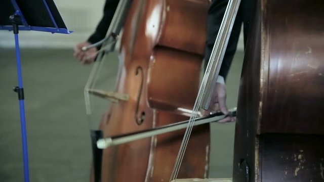 Contrabass fiddlestick strings play music stand. Close-up