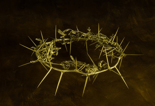 Photo of gold crown of thorns on brown grunge background