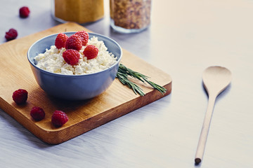 Diet curd with raspberry in a cup on a table.