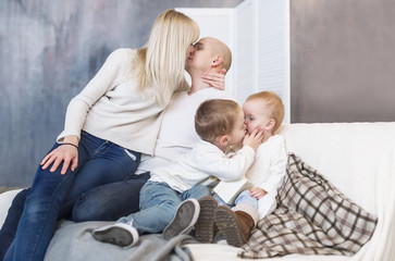 Obraz premium The kissing parents and children. Family happiness and love. Happy parents and children.