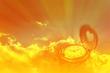 Watch or clock in dreamy sun ray light emerge or spread trought the big dark cound golden sky