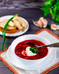 Ukrainian borscht in white plate on dark table