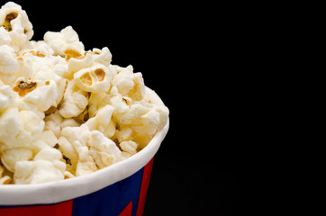 Box of fresh popcorn on black background