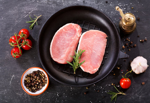 fresh pork in a pan with ingredients for cooking