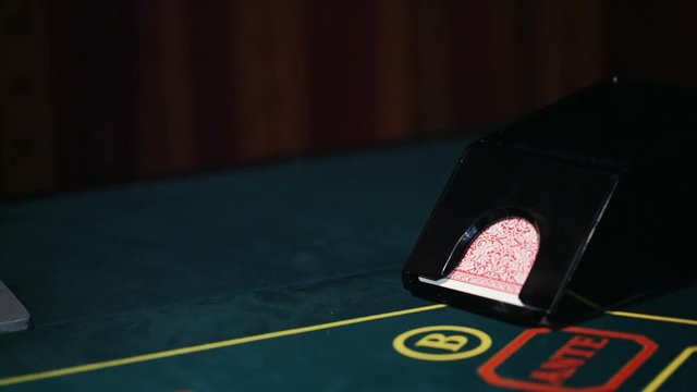 Dealer in casino deals the cards by the card feeder.