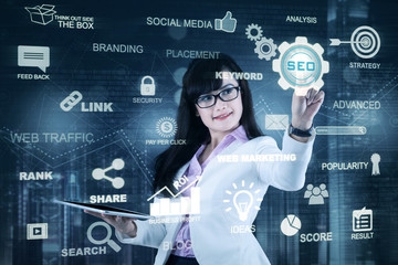 Woman holds tablet and pressing SEO icon