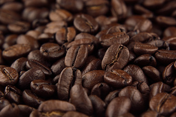 Roasted coffee beans closeup top view as background.