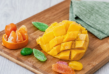 cut half a mango candied fruit, lying on a wooden Board