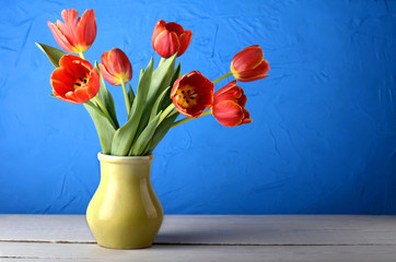 bouquet flowers tulips vase white wooden table blue textured background