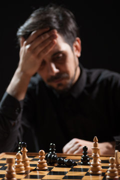 Portrait of adult man who capitulated in chess game. Focus on king figure.