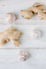 Garlic and ginger on white wooden surface.