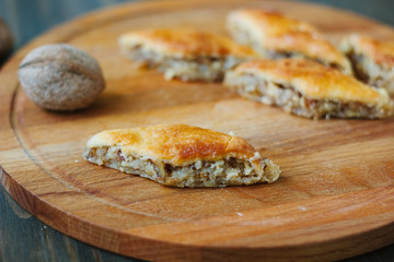 Baklava on wooden board over rustic table.