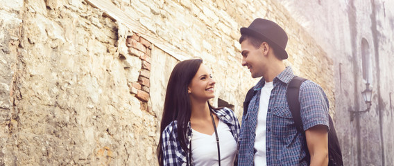 Traveling couple of hipsters: walking around old town. Vacation, summer, holiday, tourism: concept.