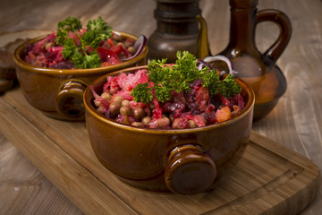 Russian beetroot salad vinaigrette Keramiktopf on wood background
